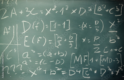 side view of math formulas and calculation written over chalkboard. selective focus. 