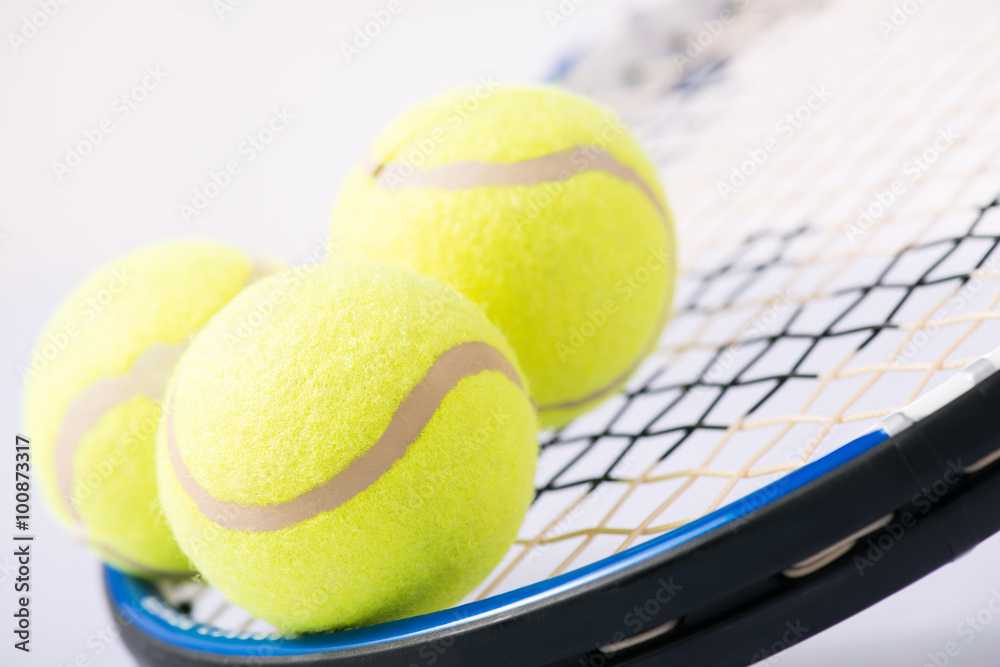 Three tennis balls and a racket. 