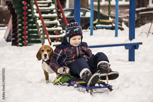beagle dog and boy in winter snow