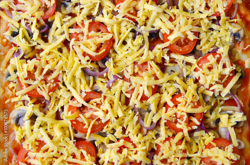 tasty pizza. close up pizza before baking. texture of vegetables and grated cheese, appetizing