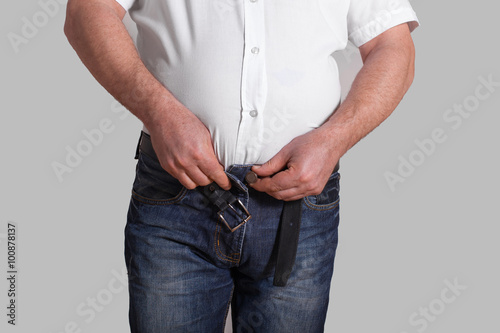 the fat man tries to clasp jeans