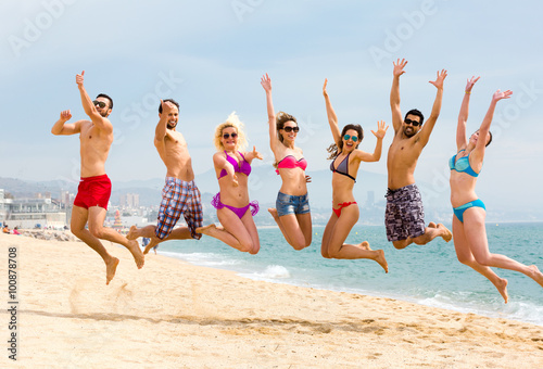 Men and women jumping on beach