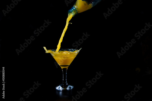the orange juice is poured from a bottle