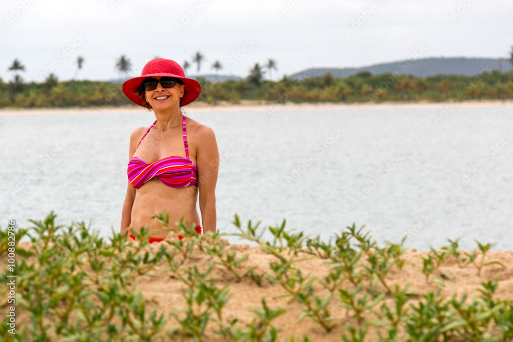 Woman on Beach in a Bikini Wearing a Red Hat