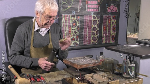 a craftsman jeweler creates a bracelet