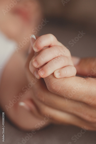 Newborn baby holding mother's finger © GTeam