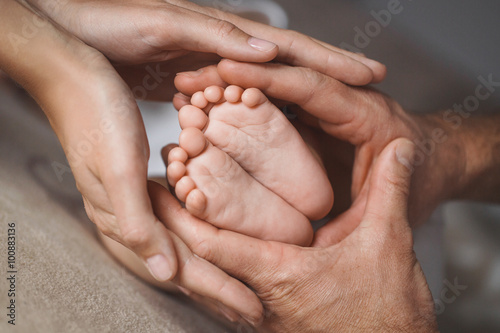 Children's feet in hands of mother and father. photo