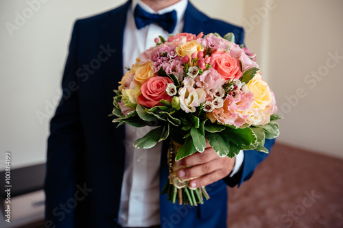 Beautiful wedding bouquet in rustic style in the grooms hands