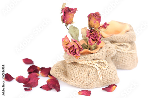 Bouquet of dried withered roses in sackcloth bag on white backgr photo