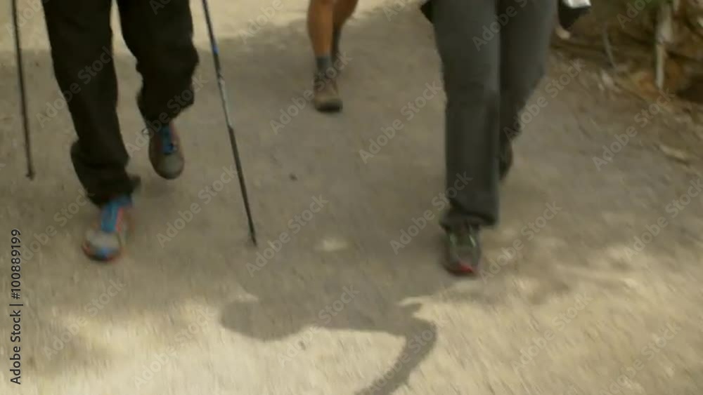 Friends smile and talk while they hike together Friends smile and talk while they hike together