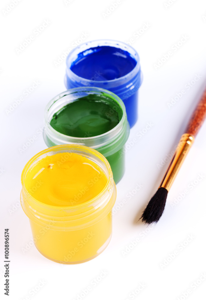 Jars with colored gouache and paint brushes.