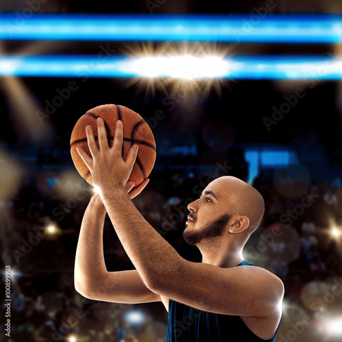 Bald sportsman playing basketball and thorws a ball