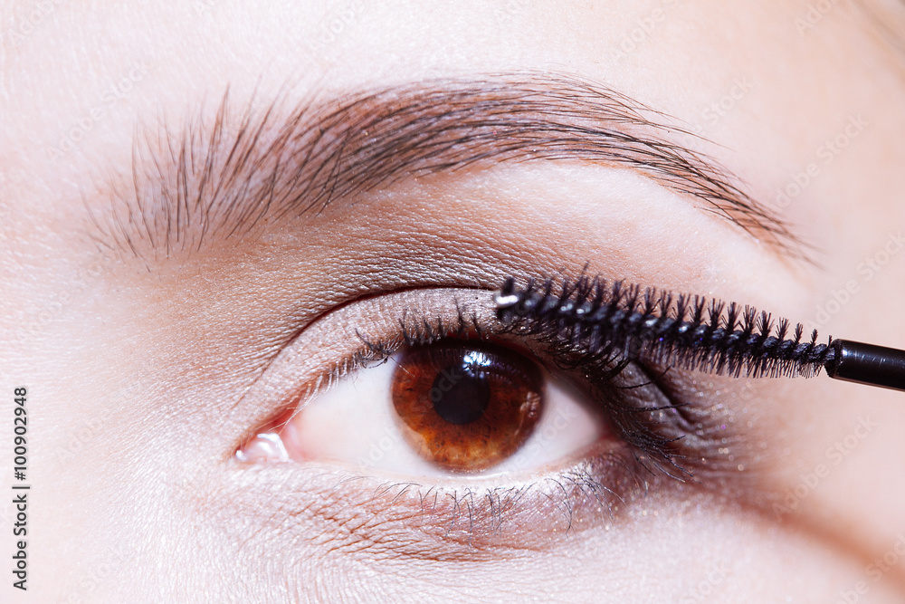 Fototapeta premium Woman applying mascara on her eyelashes
