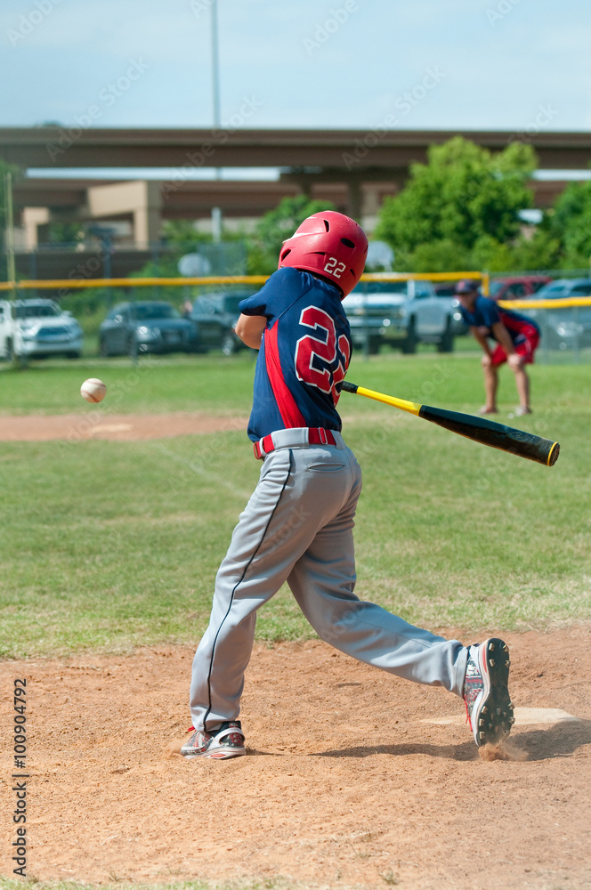 Youth baseball player swinging bat