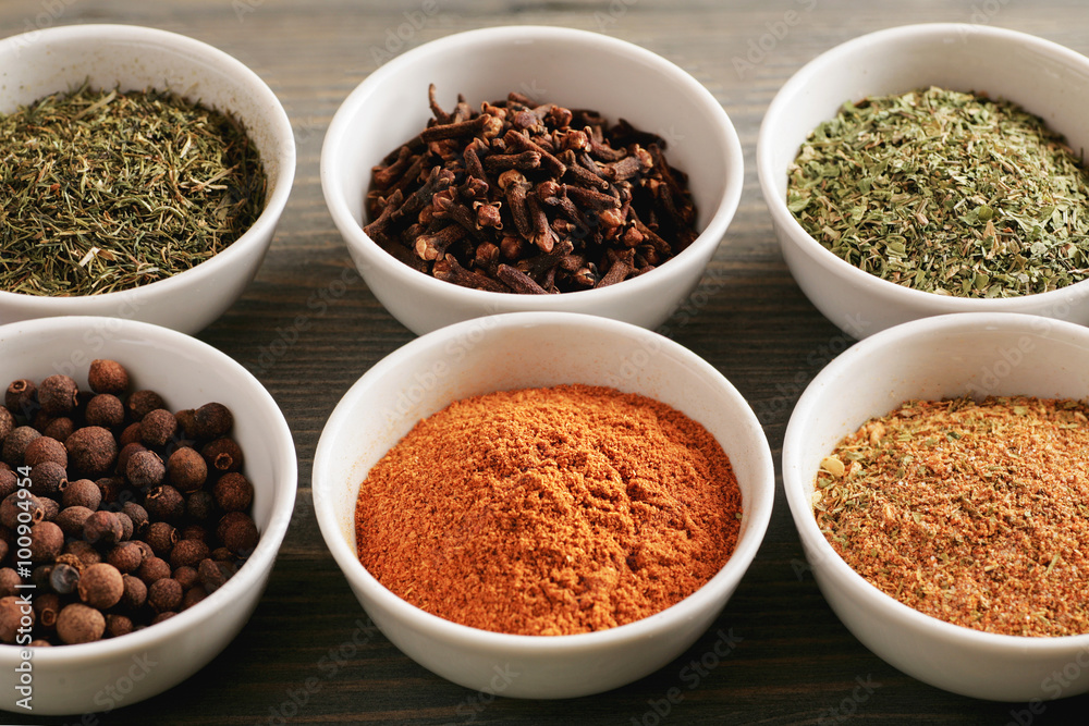 Colored spices in white ceramic bowls