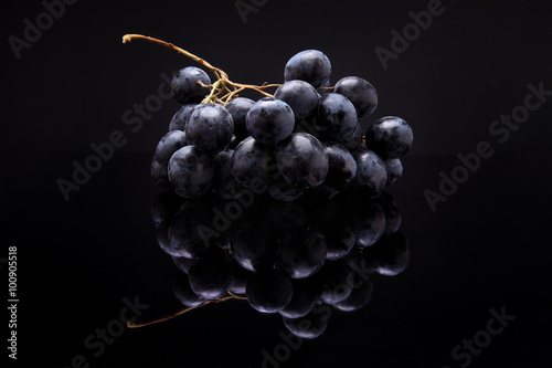 Closeup image of black grapes on black background with reflectio photo