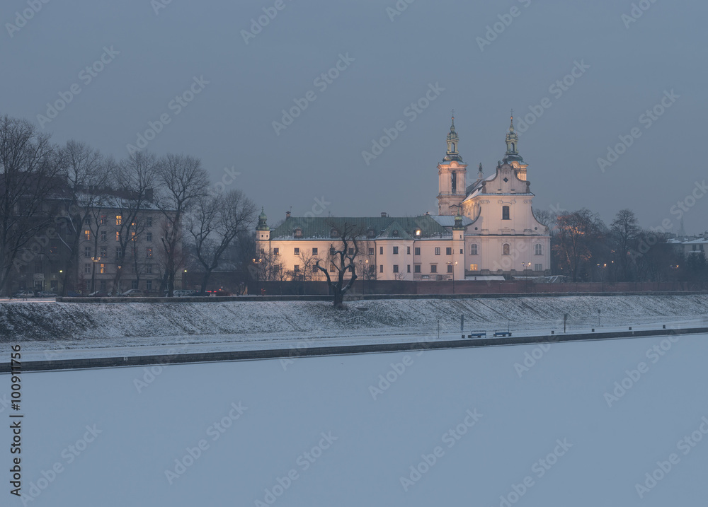 Krakow, Poland, frozen Vistula riverbank with Pauline fathers church (Skalka) in the evening