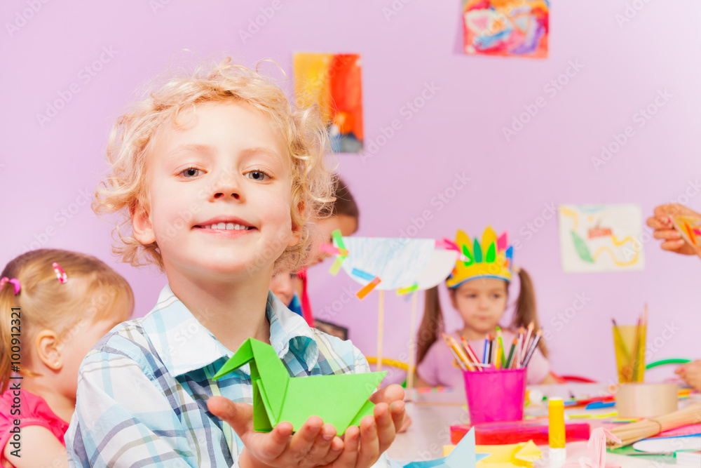 Kids in kindergarten make origami, portrait of boy Kids in kindergarten make origami, portrait of boy