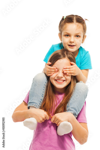 Little sister sitting on elder sister's shoulders