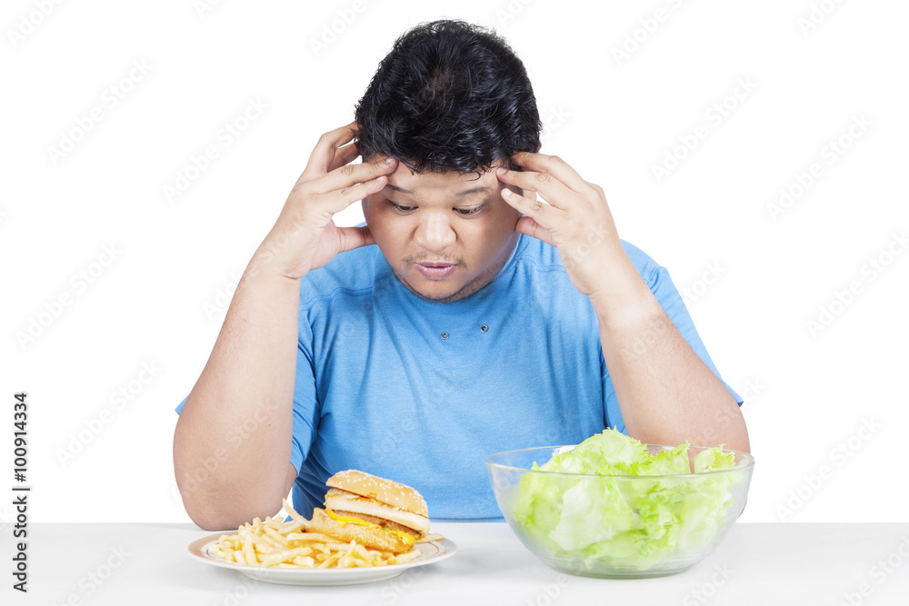 Confused person choosing hamburger or salad Confused person choosing hamburger or salad