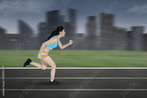 Female runner running on a track © Creativa Images