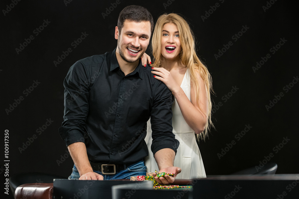 Young couple celebrating win at roulette table in casino. Young couple celebrating win at roulette table in casino.