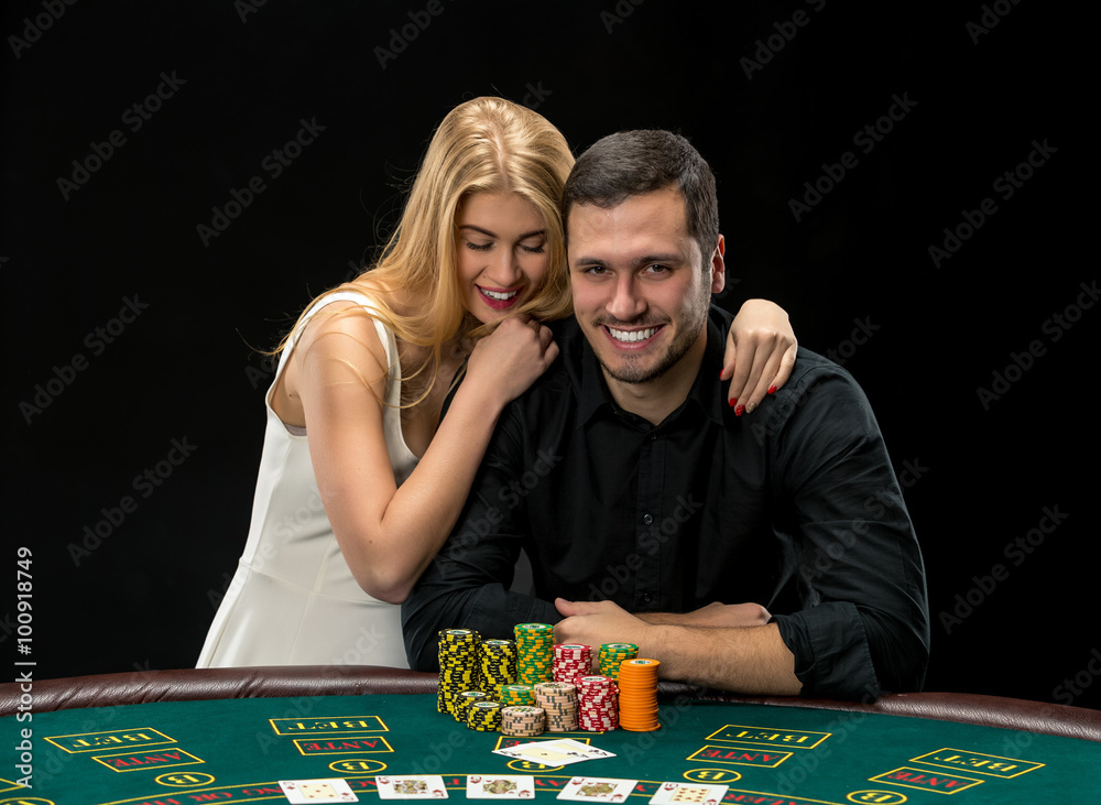 Young сouple playing poker have a good time in casino Young сouple playing poker have a good time in casino