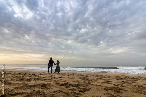Couple walking at Sunset in Dar Bouazza beach  in Tamarist