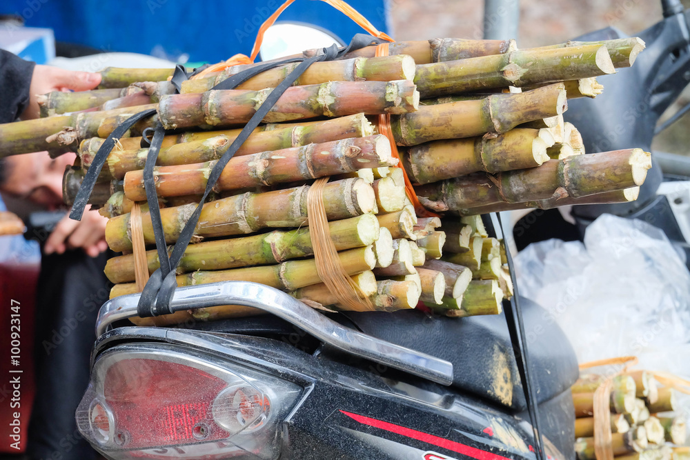A motocycle carring sugar canes
