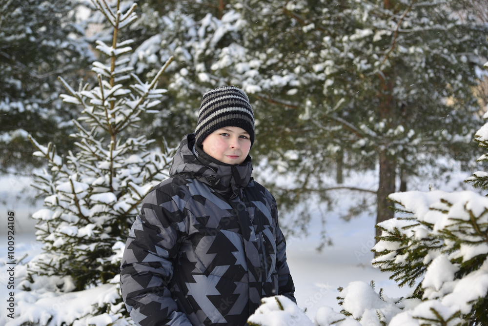teenage boy at a pine forest in winter teenage boy at a pine forest in winter