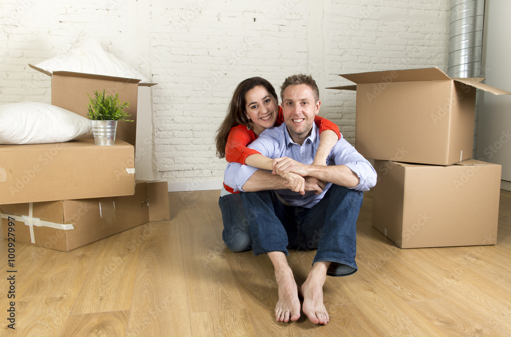 young happy couple sitting on floor together celebrating moving in new flat house or apartment young happy couple sitting on floor together celebrating moving in new flat house or apartment