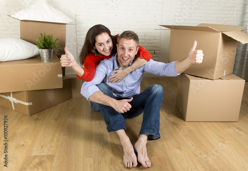 young happy couple sitting on floor together celebrating moving in new flat house or apartment © Wordley Calvo Stock