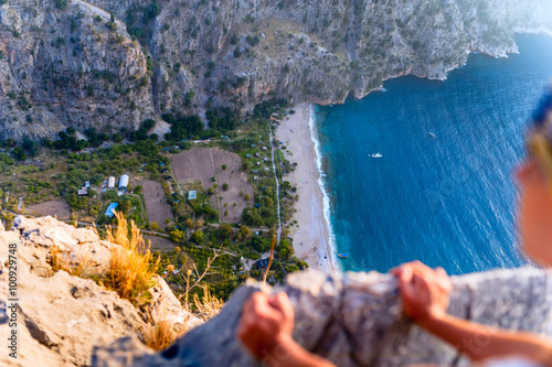 Man looking at the sea and the valley down the cliff. man looks