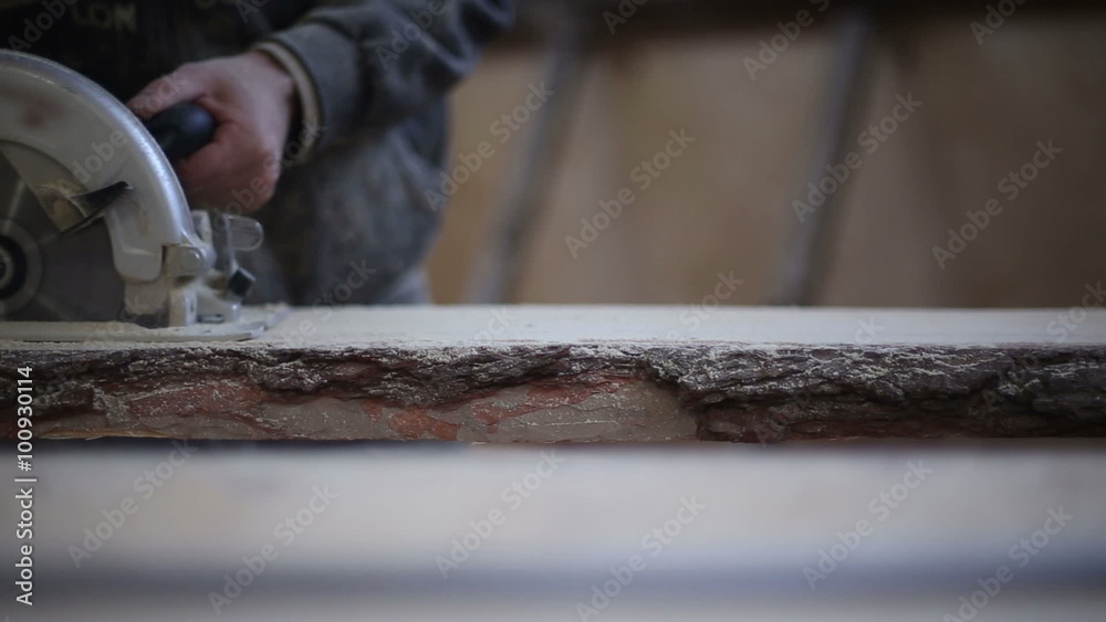 A carpenter saws off a board with a manual disk saw in a carpentry workshop
A carpenter saws off a board with a manual disk saw in a carpentry workshop