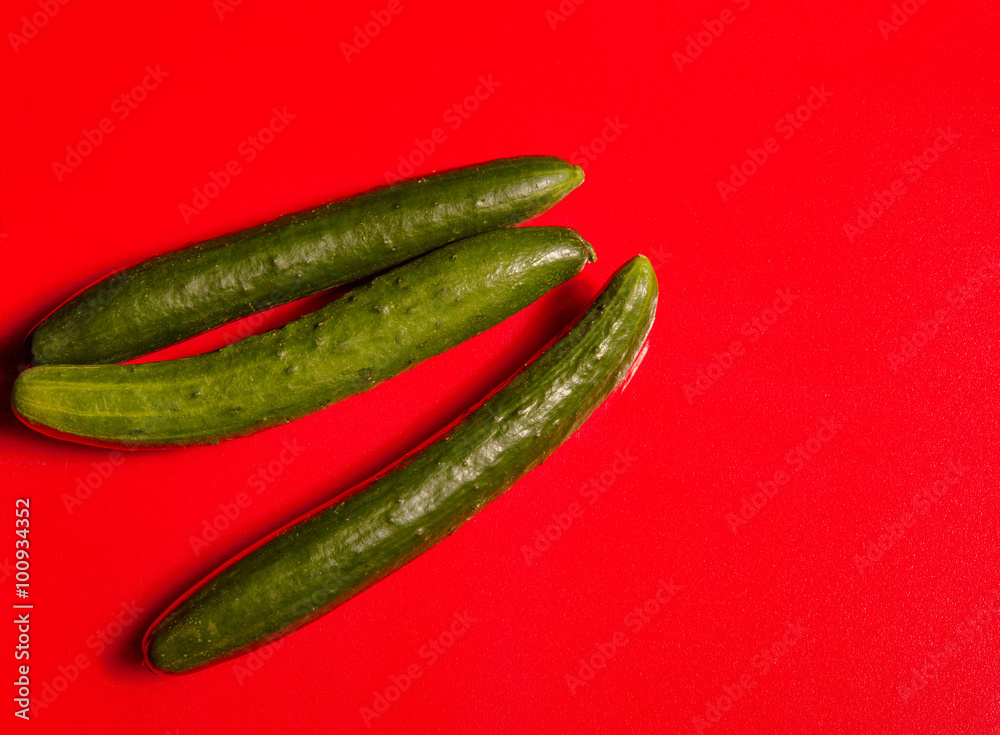 Japanese cucumbers on a bright red cutting board Japanese cucumbers on a bright red cutting board