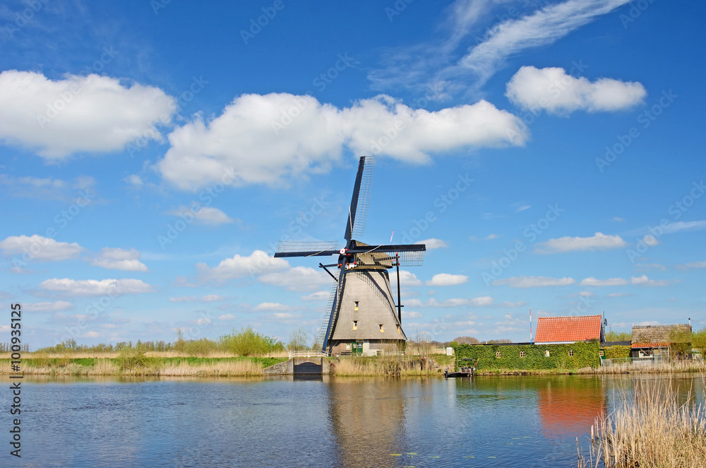 Fantastic landscape with windmills at the river against the back