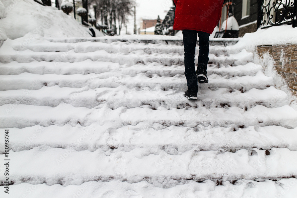 woman climbs the stairs in the snow