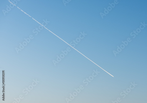 White Condensation Trail From an aeroplane flying across a beautiful blue sky