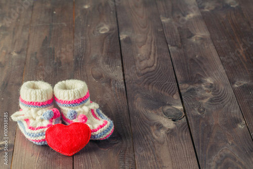 Baby booties on rustic wooden background photo