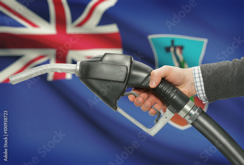 Fuel pump nozzle in hand with national flag on background - Montserrat photo