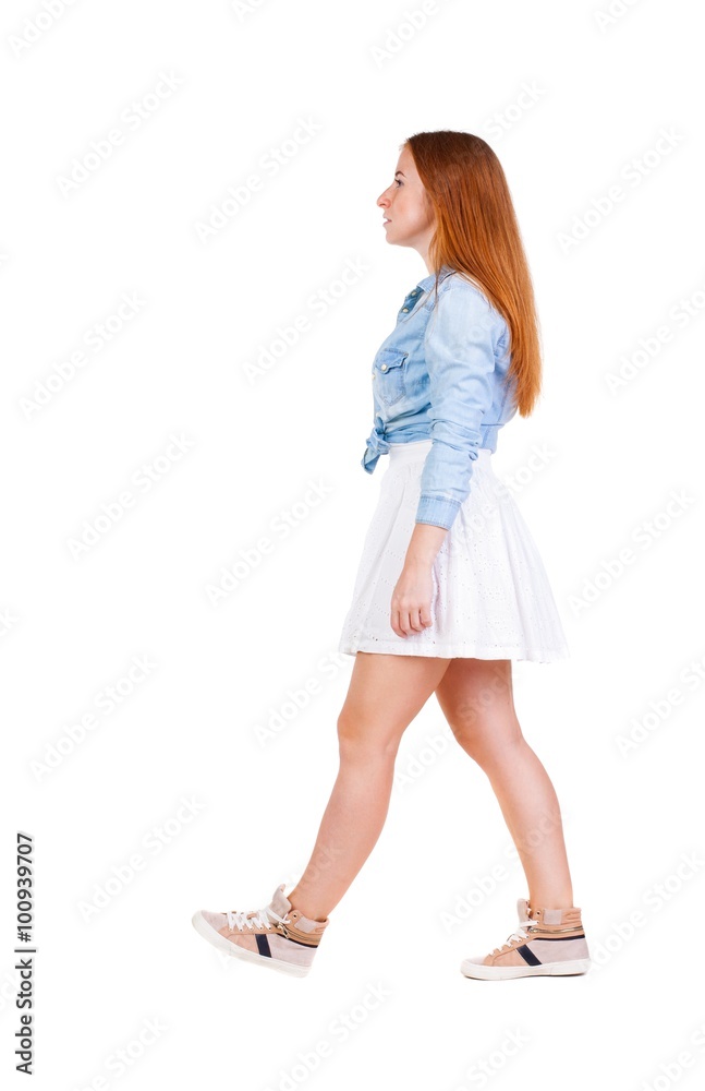 back view of walking woman in dress. beautiful redhead girl in back view of walking woman in dress. beautiful redhead girl in