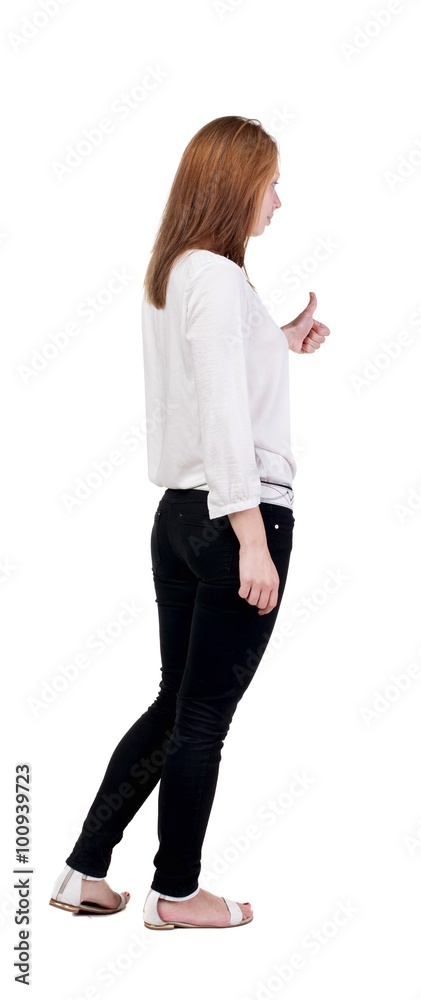 back view of standing young redhead business woman showing thumb back view of standing young redhead business woman showing thumb