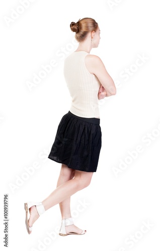 back view of walking woman in dress. beautiful blonde girl in m