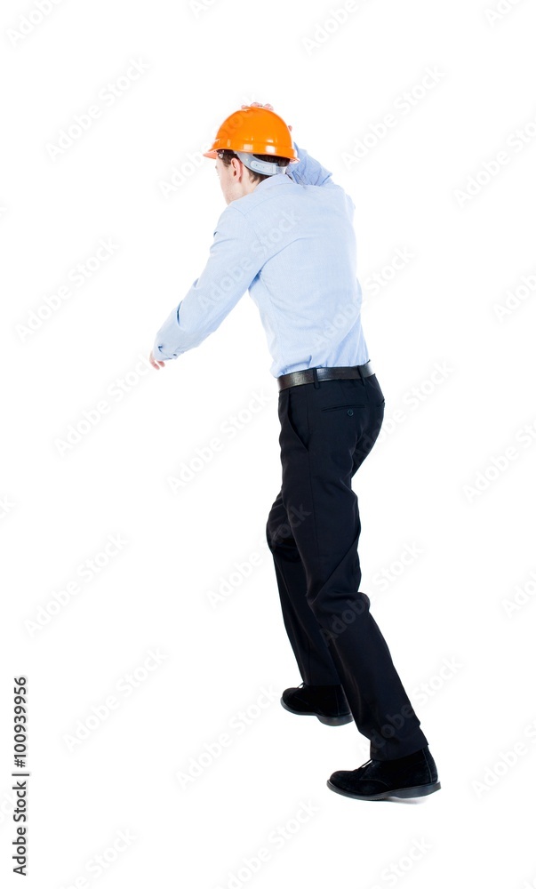 Back view of running engineer in helmet. Walking guy in motion. Rear view people collection. Backside view of person. Isolated over white background. on top of a man holding a helmet runs Back view of running engineer in helmet. Walking guy in motion. Rear view people collection. Backside view of person. Isolated over white background. on top of a man holding a helmet runs