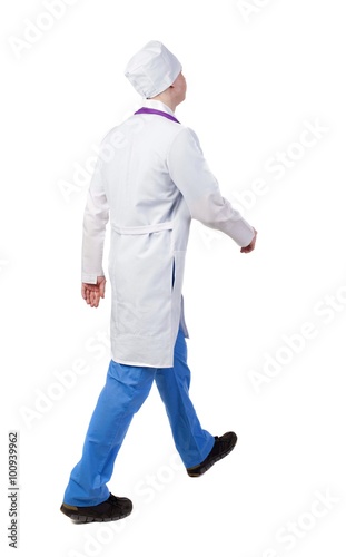 Back view of walking doctor in a robe hurrying to help the patie