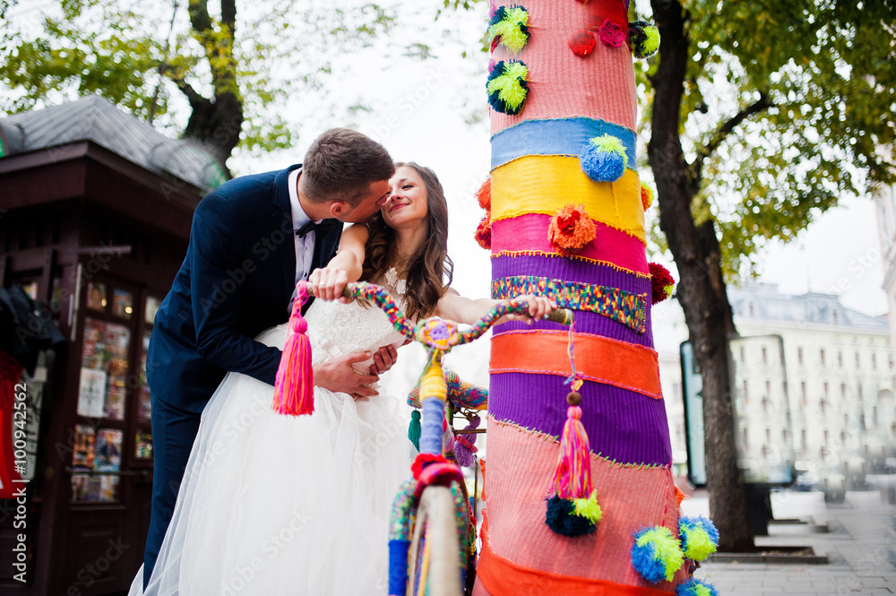 Obraz premium Wedding couple near colored tree with bicycle