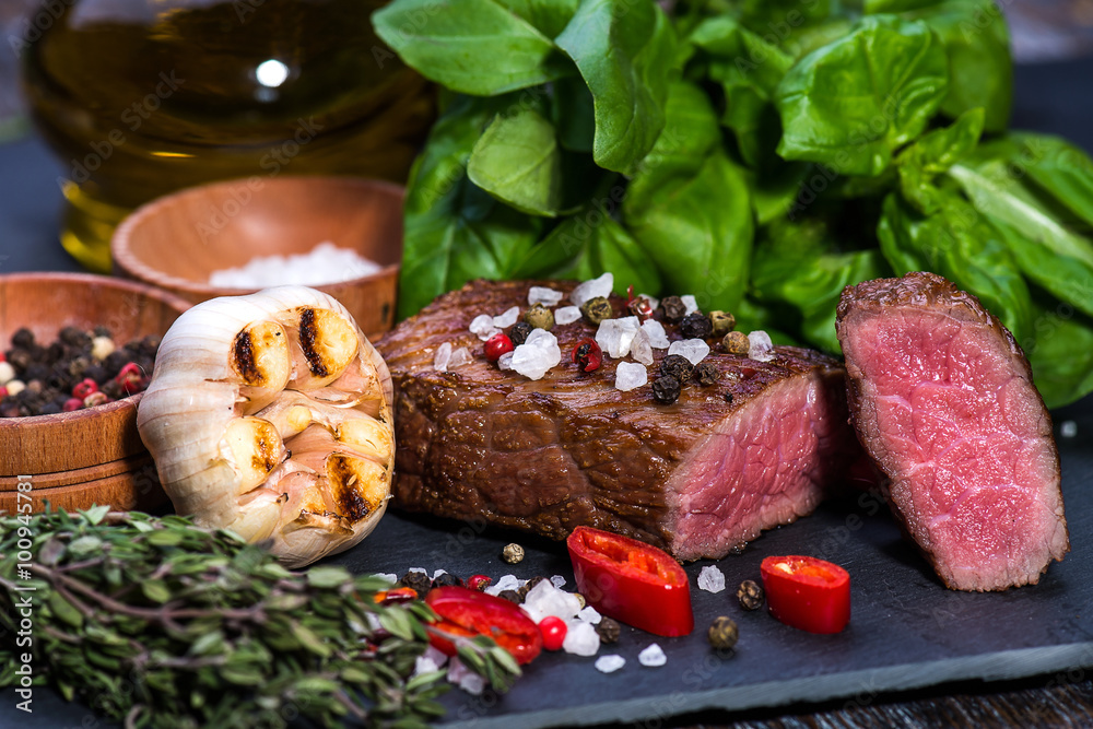 Beef Steak, medium, salt, pepper, garlic, rosemary  on the black board, background.