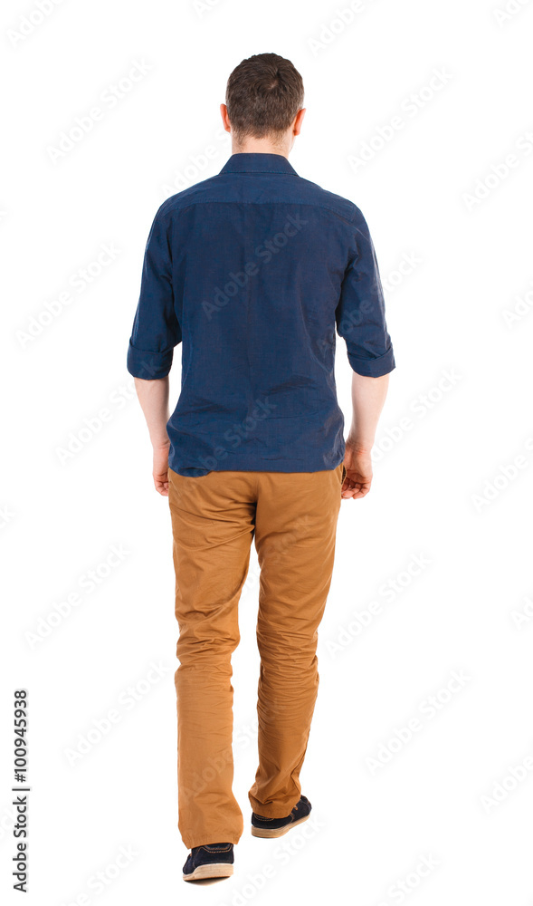 Fototapeta premium Back view of going handsome man in jeans and a shirt.