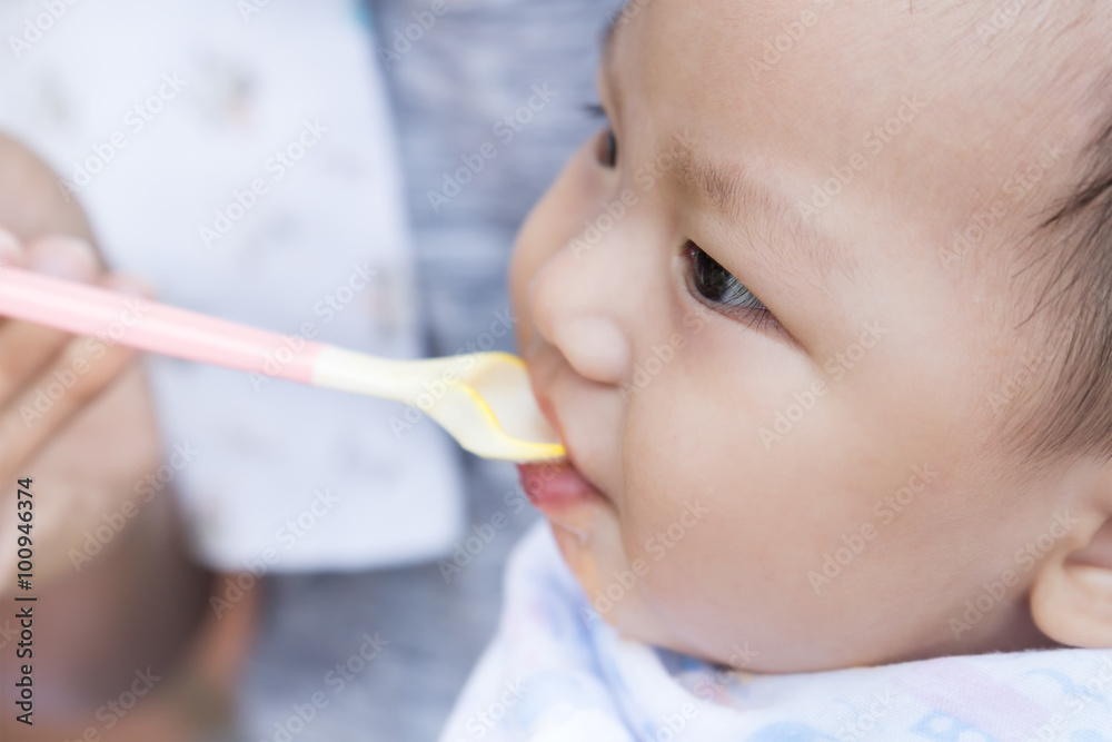 Father feeding baby food to cute newborn baby Father feeding baby food to cute newborn baby