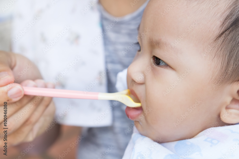 Father feeding baby food to cute newborn baby Father feeding baby food to cute newborn baby